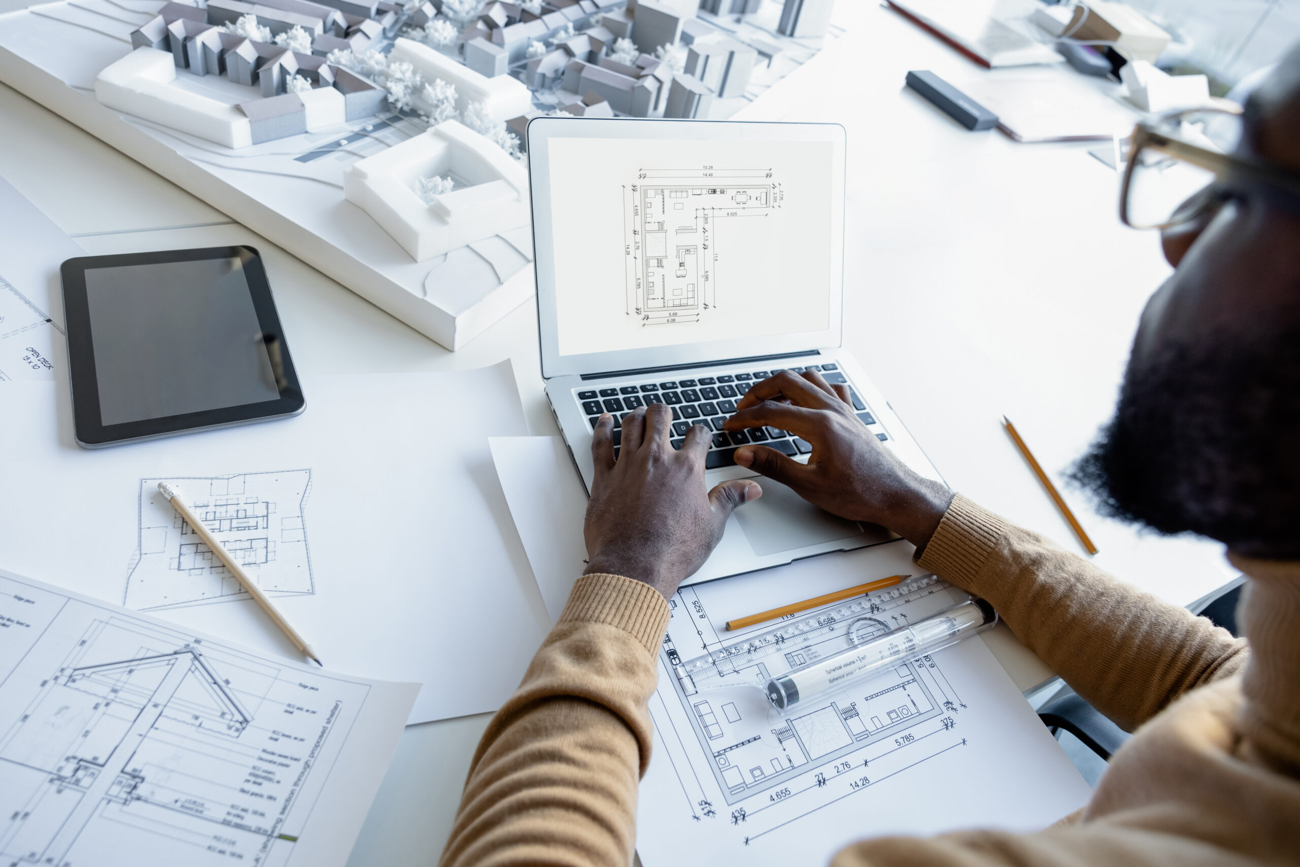 Experienced multicultural man architect planning new house using the internet in the office
